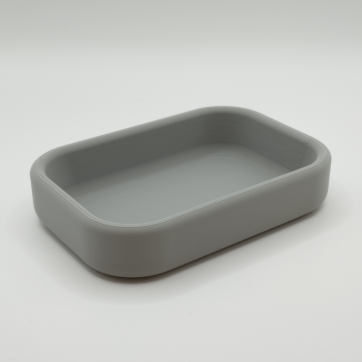Minimalistisch sleutelbakje op een gangtafel met sleutels en een plant