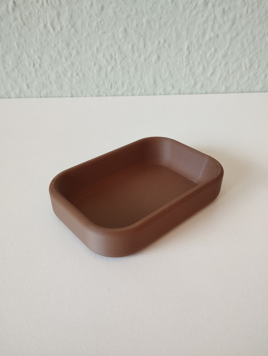 Modern sleutelbakje in een zachte neutrale kleur, close-up van het gladde oppervlak