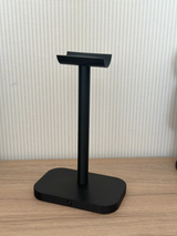 Minimalistische koptelefoonstandaard met strakke gebogen arm en compacte voet