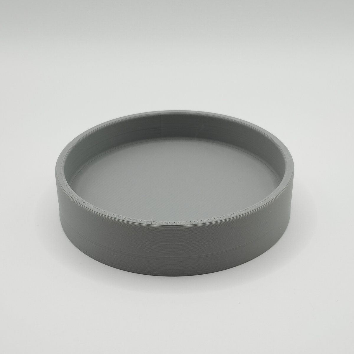 Rond sleutelbakje op een haltafel met sleutels en kleine spulletjes