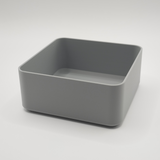 Witte minimalistische vierkante schaal op een houten salontafel met afstandsbediening en sleutels