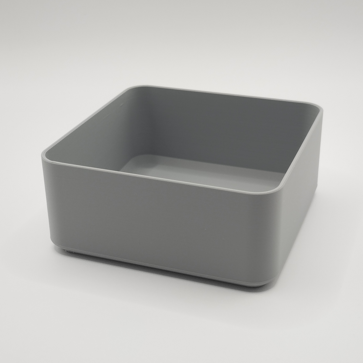Witte minimalistische vierkante schaal op een houten salontafel met afstandsbediening en sleutels