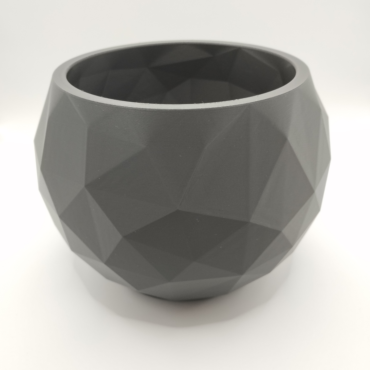Low poly schaal op een witte plank met minimalistische decoratie in een zacht Scandinavisch interieur