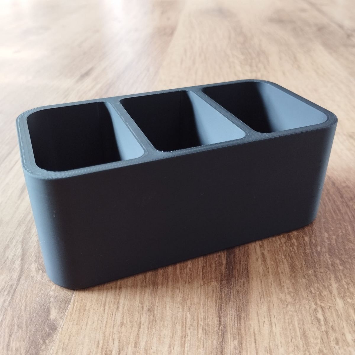 Minimalistische afstandsbedieningshouder met strakke lijnen en open design