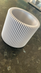 Close-up van een geribbelde pennenhouder met platte verticale ribbels en minimalistisch design