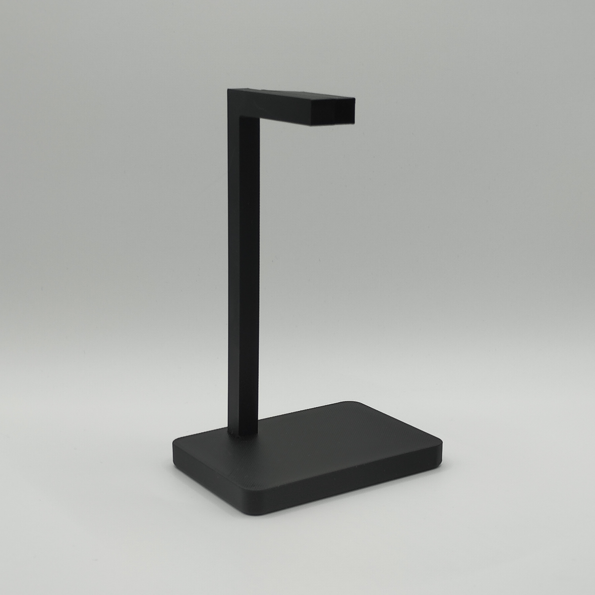 Minimalistische koptelefoonstandaard met gamingheadset op een modern bureau