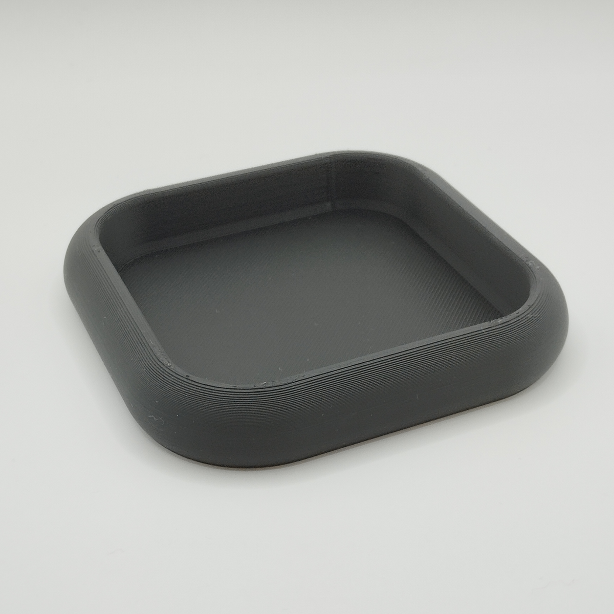 Wit rond sleutelbakje op een wandtafel in de hal met sleutels en munten