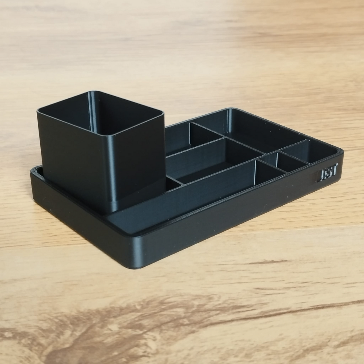 Close-up van een minimalistisch bureaubakje en potlodenbeker met strakke lijnen