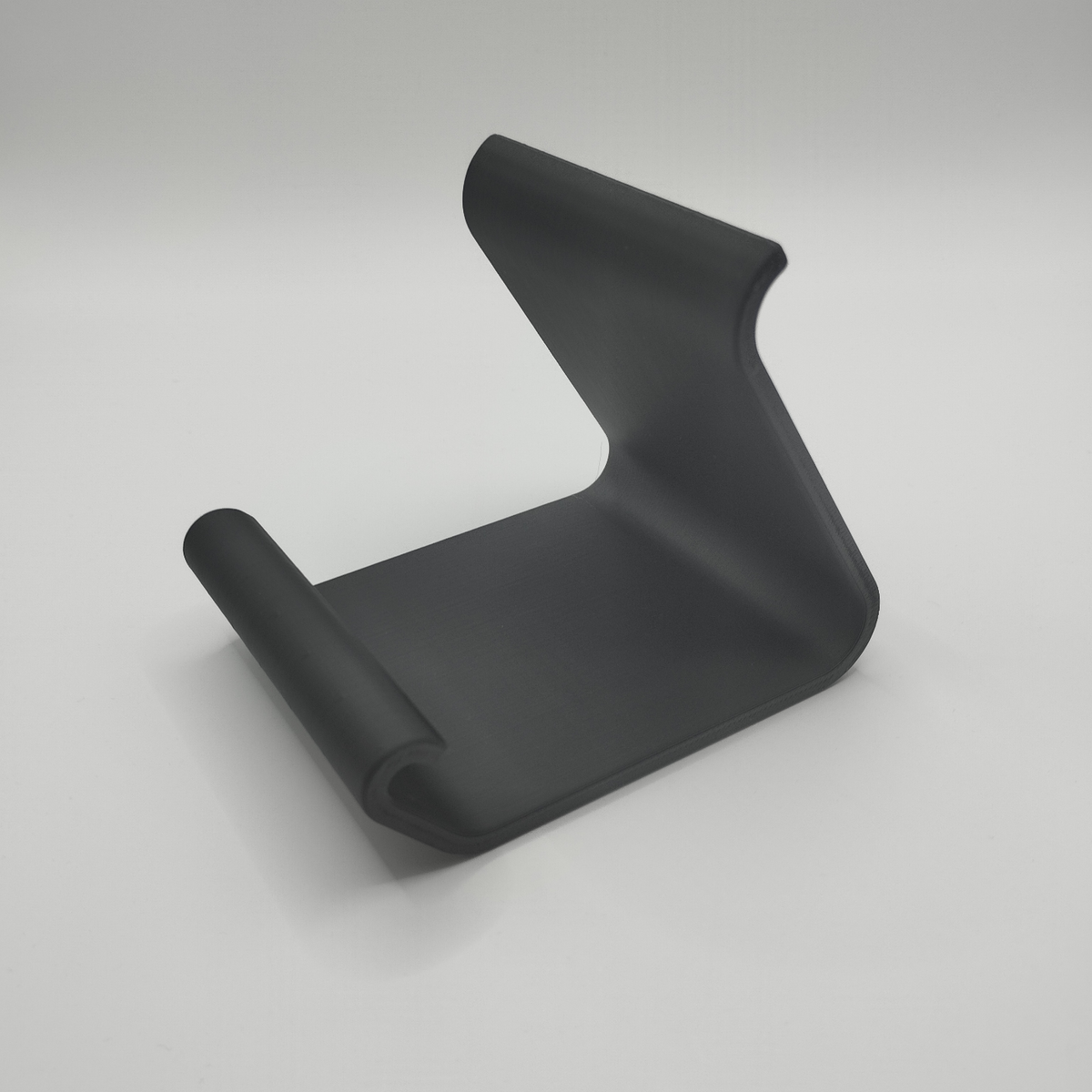 Gebogen telefoonhouder op een houten bureau met een iPhone