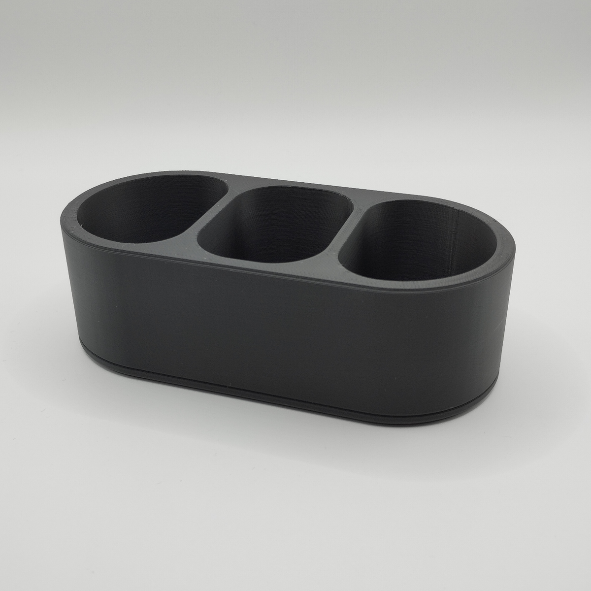 Minimalistische afstandsbedieningshouder op een houten salontafel met afstandsbedieningen en kleine spulletjes