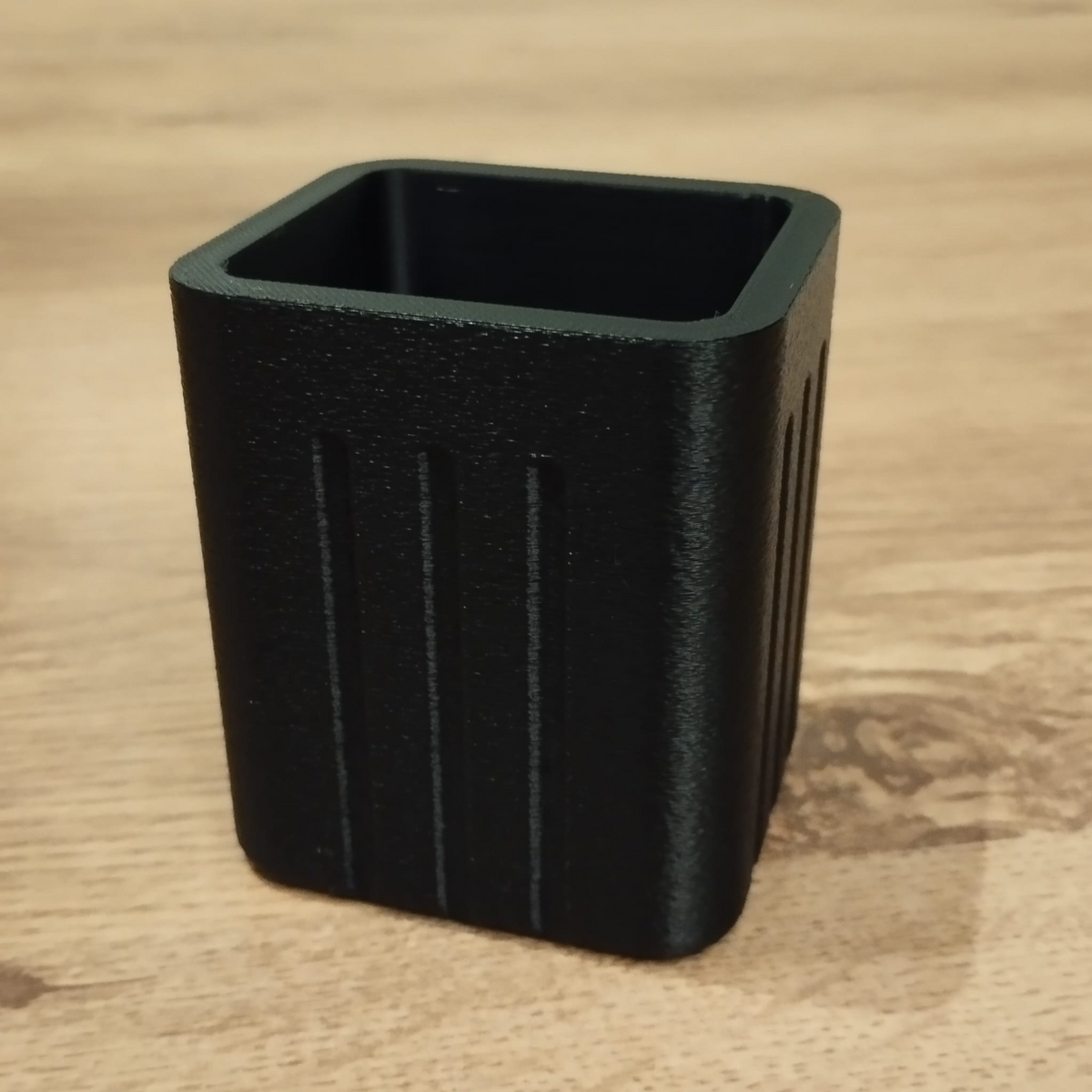 Close-up van een minimalistische vierkante pennenhouder met geribbelde zijkanten