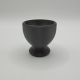 Twee minimalistische eierdopjes op een eenvoudige houten tafel met verse eieren