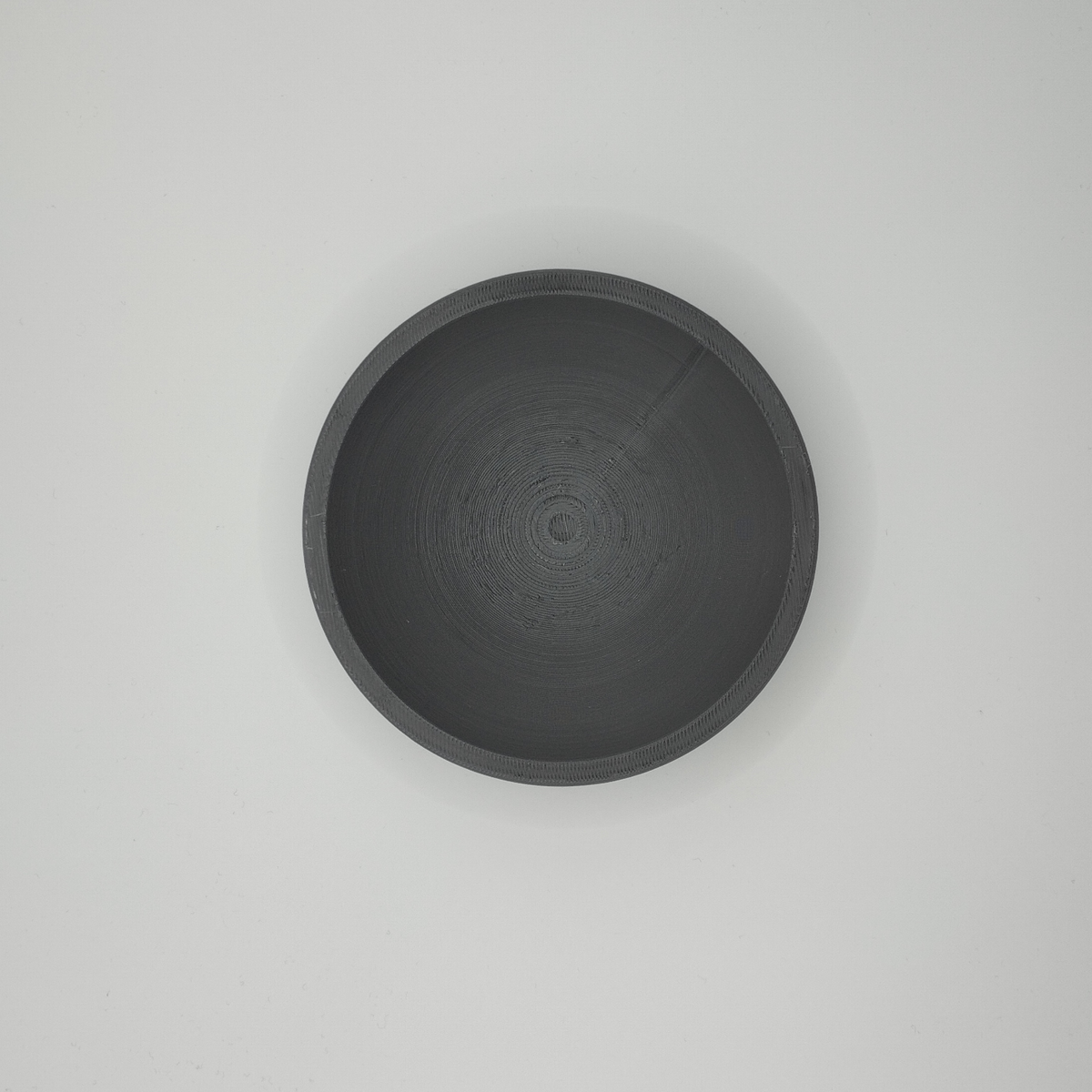 Witte platte schaal voor sleutels en munten met geometrisch silhouet, close-up