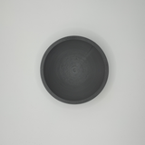 Witte platte schaal voor sleutels en munten met geometrisch silhouet, close-up