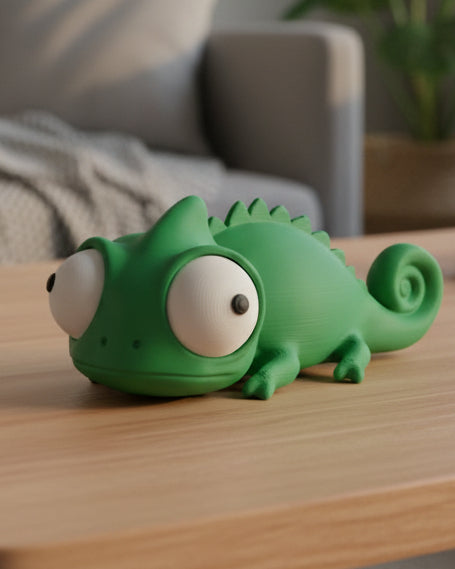 Close-up van een grappig kameleonfiguurtje met grote beweegbare googly eyes op een wit vlak