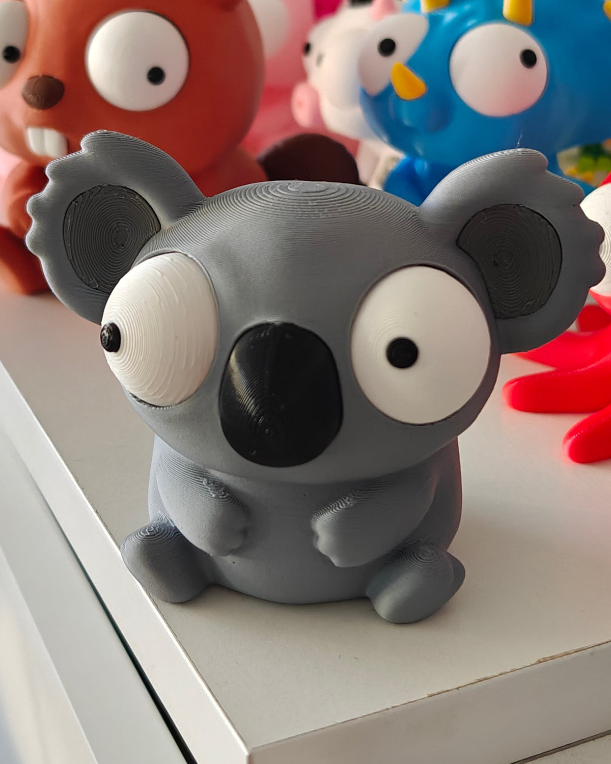Close-up van de grote verplaatsbare googly eyes van het koalafiguurtje met verschillende uitdrukkingen
