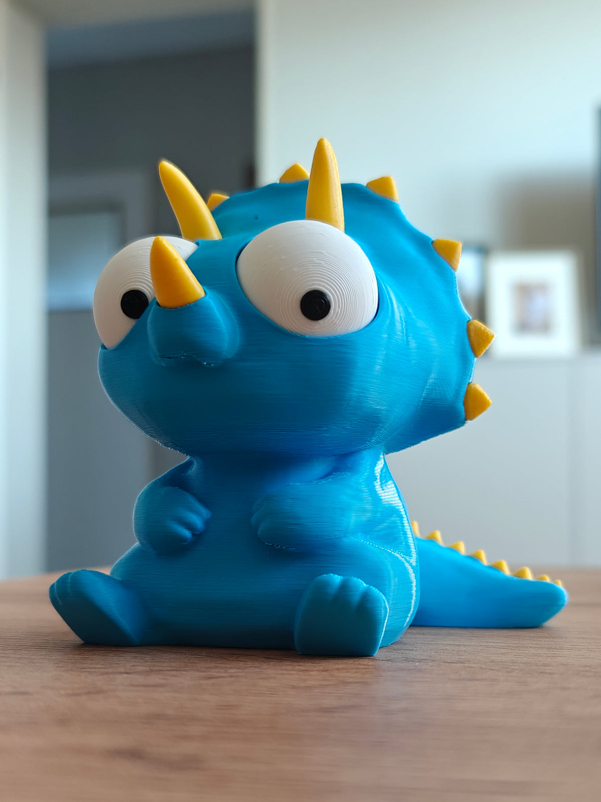 Gek triceratopsfiguurtje met beweegbare ogen, close-up op witte achtergrond