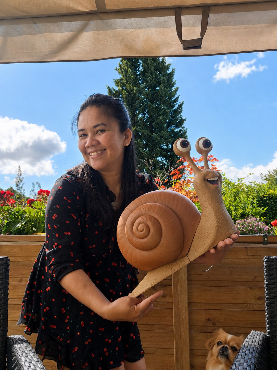 Iemand houdt het grote tuinslakkenbeeld vast in een tuin, zodat je de grootte van 45 cm ziet