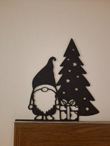 Kabouterfiguurtje met cadeautje bij de kerstboom