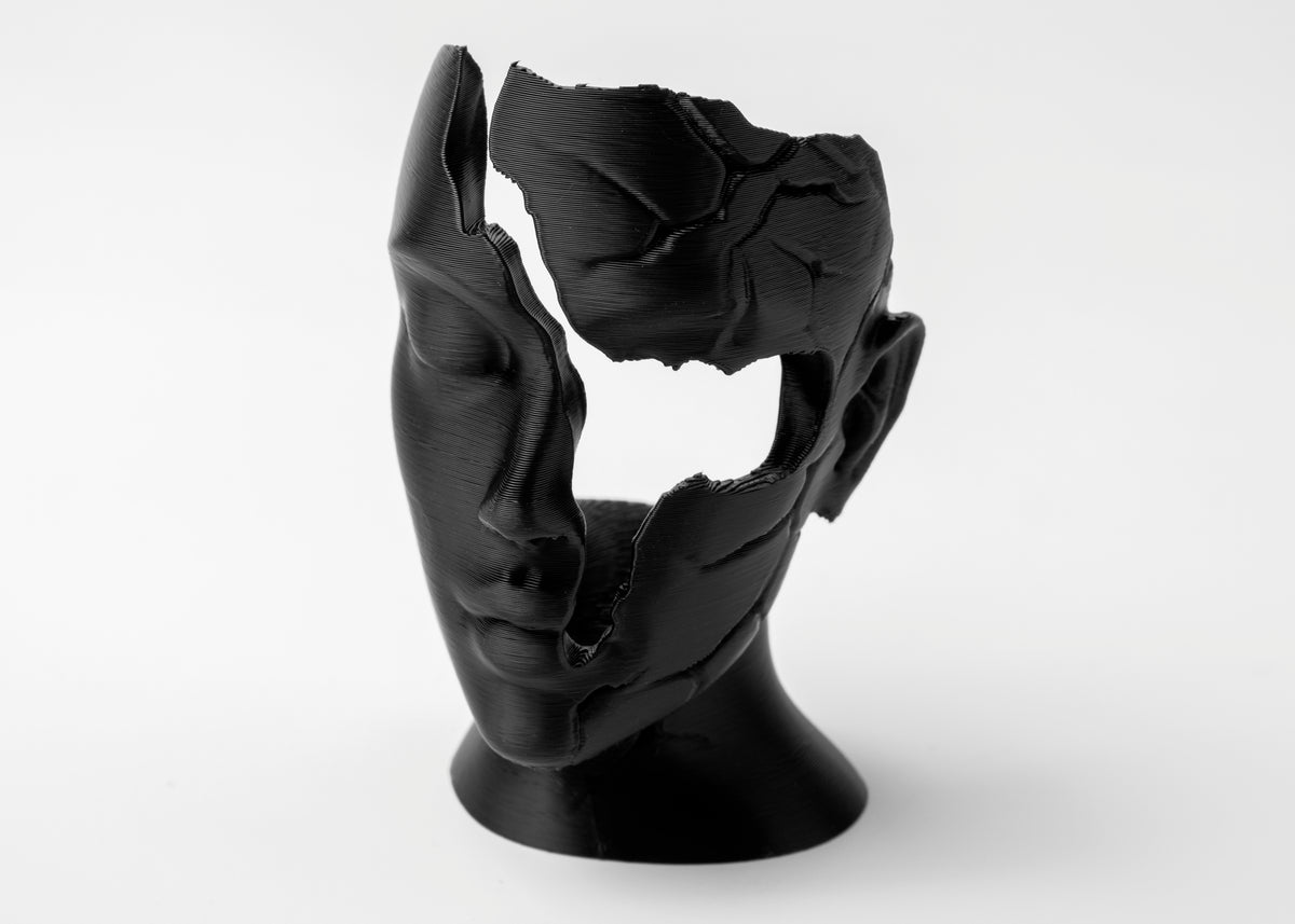 Abstract gebroken vrouwengezicht als beeld op een houten plank bij matte keramiek