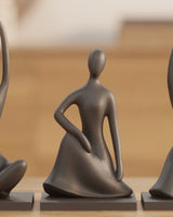 Drie abstracte mensfiguren met matte afwerking bij elkaar op een wit oppervlak