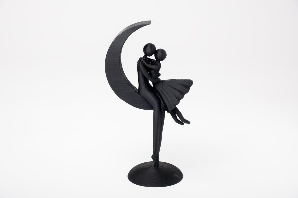 Minimalistische sculptuur van een stel op de maan op een houten plank met zachte, neutrale decoratie