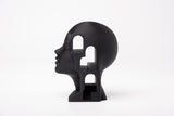 Surrealistische architectonische buste op een minimalistische boekenkast met natuurlijke decoratie