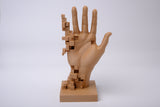 Handsculptuur in glitch art-stijl op minimalistisch bureau met boeken en kleine plant