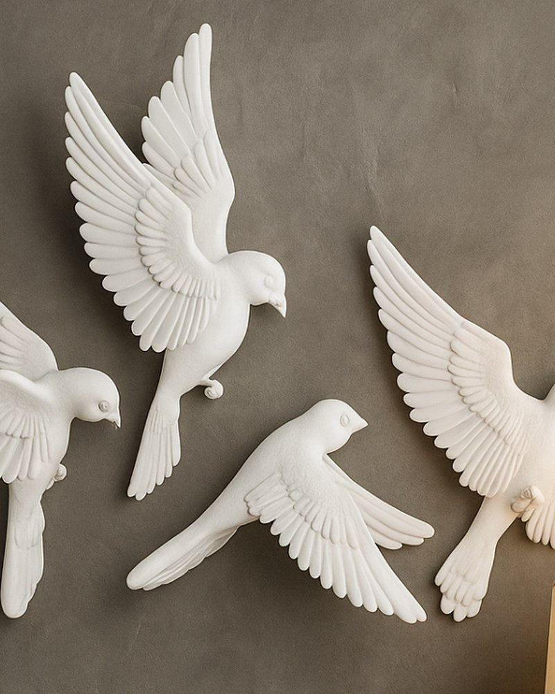 Set witte vogelbeelden voor aan de muur met matte afwerking – drie vliegende vogels tegen een witte achtergrond