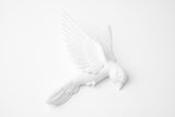 Set witte vogelbeelden voor aan de muur met matte afwerking – drie vliegende vogels tegen een witte achtergrond