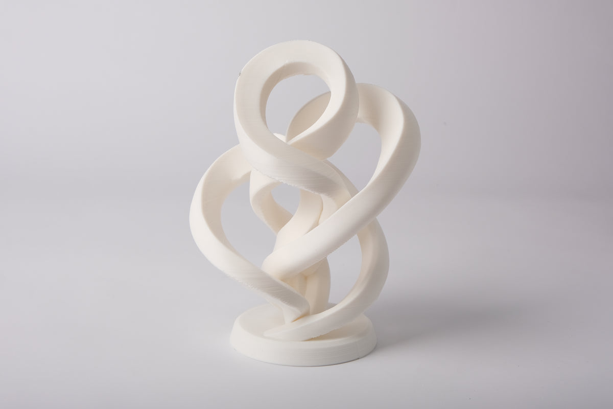 Minimalistische abstracte oneindigheidssculptuur op een lichte houten plank met neutrale decoratie
