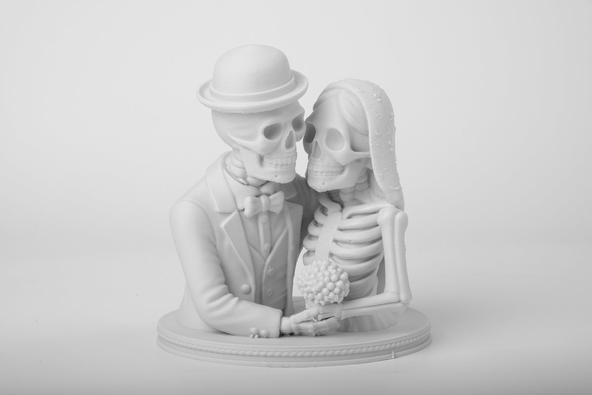 Gotisch skeletbruidspaar-figuur op donkere houten plank samen met kaarsen en sombere decoratie