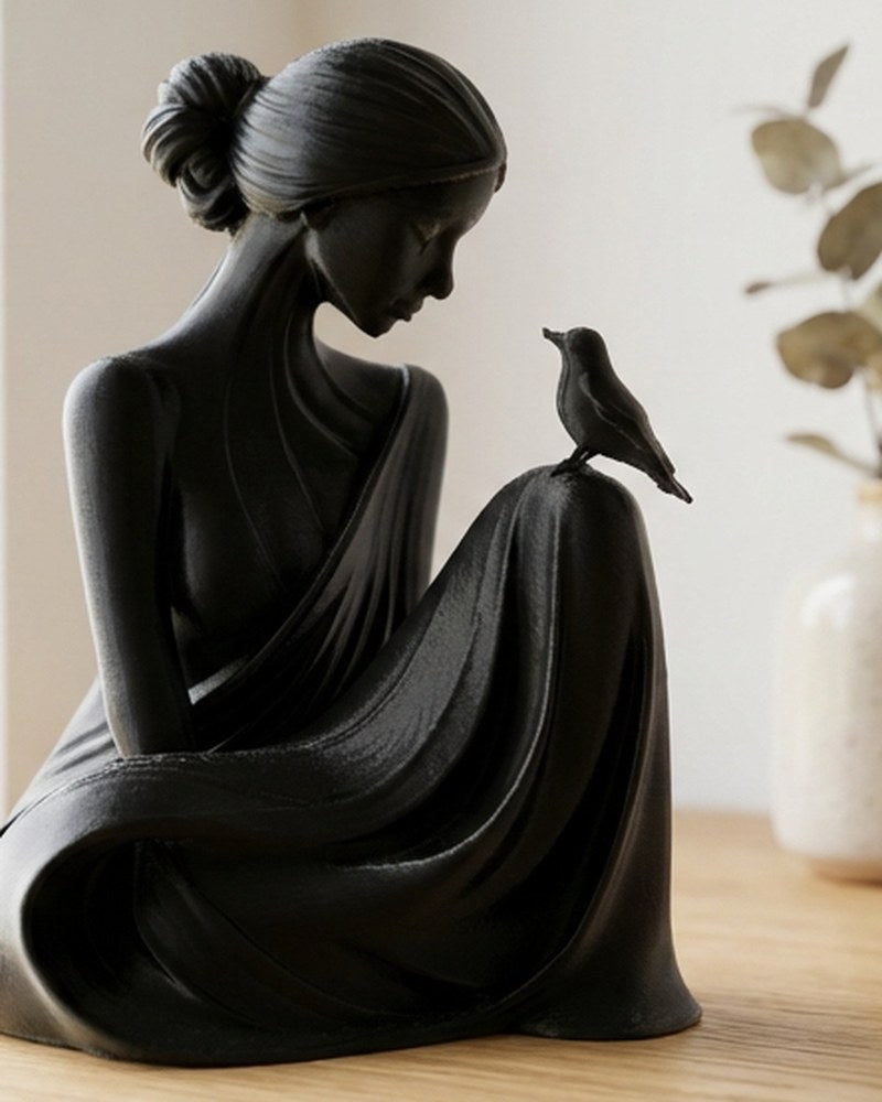 Minimalistische witte sculptuur van een vrouw en een vogel, vooraanzicht op een licht oppervlak