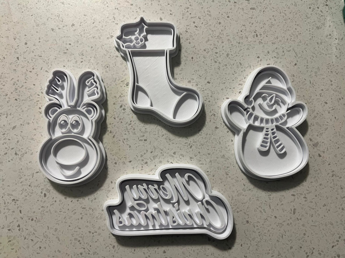 Koekjesuitsteekvormen en stempels met sneeuwpop, rendier en kerstsok