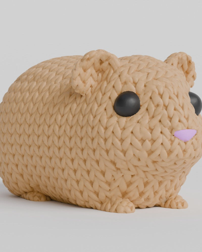 Close-up van een gebreid cavia-figuurtje met gehaakte textuur en ingezette ogen en neus, vooraanzicht