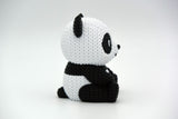 Close-up van een gebreid pandafiguurtje met zwart-witte gehaakte look