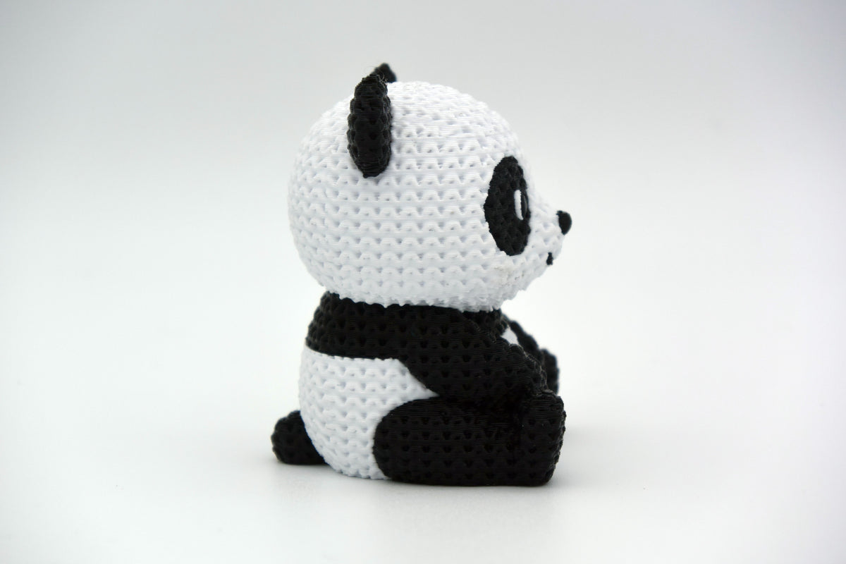 Close-up van een gebreid pandafiguurtje met zwart-witte gehaakte look