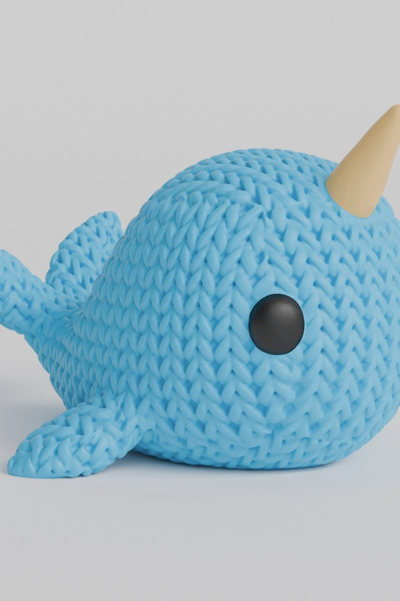 Close-up van een gebreid narwalfiguurtje met gehaakte textuur en spiraalvormige slagtand