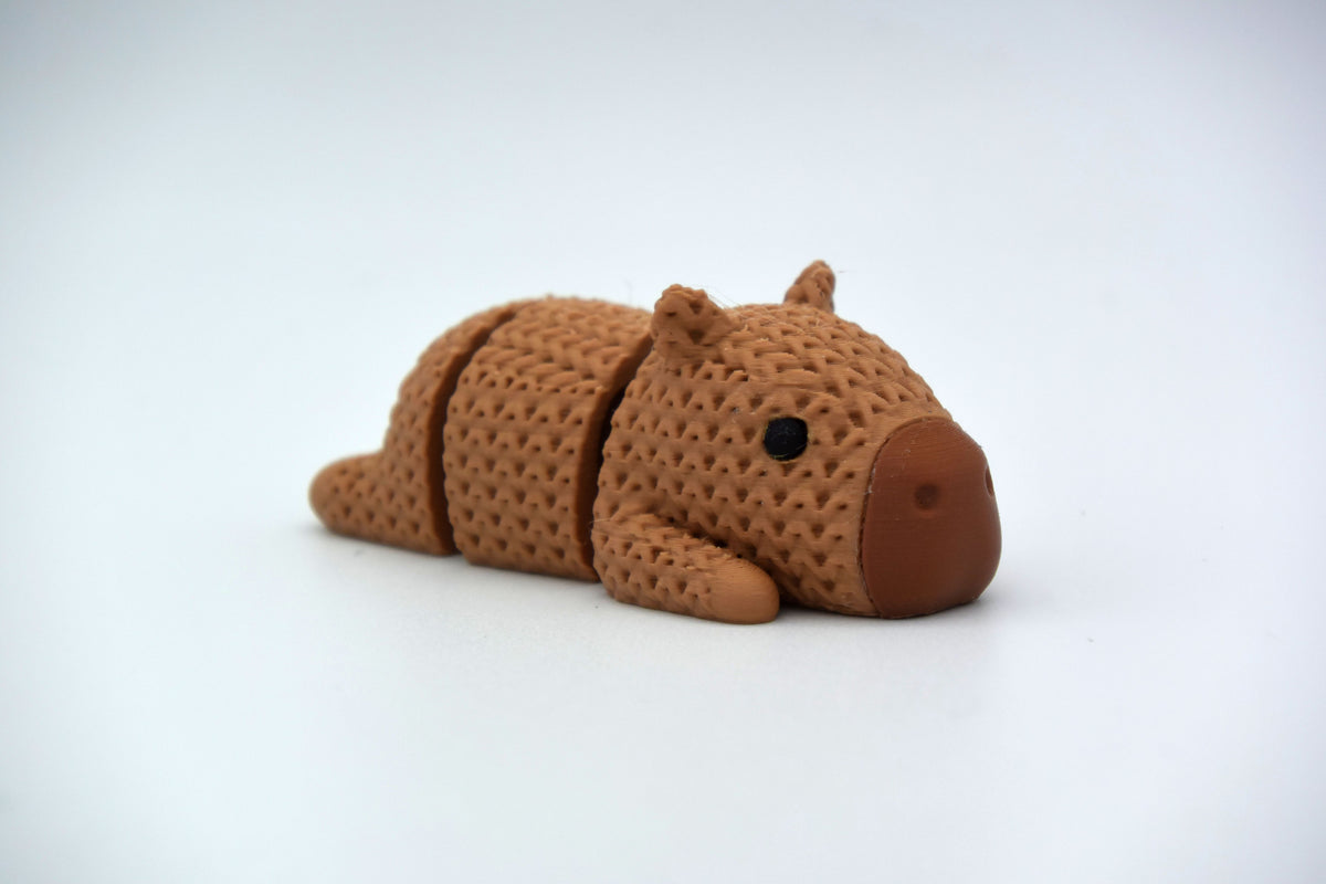 Close-up van gebreide structuur op de rug van decoratief capybarafiguurtje in warme bruine tinten