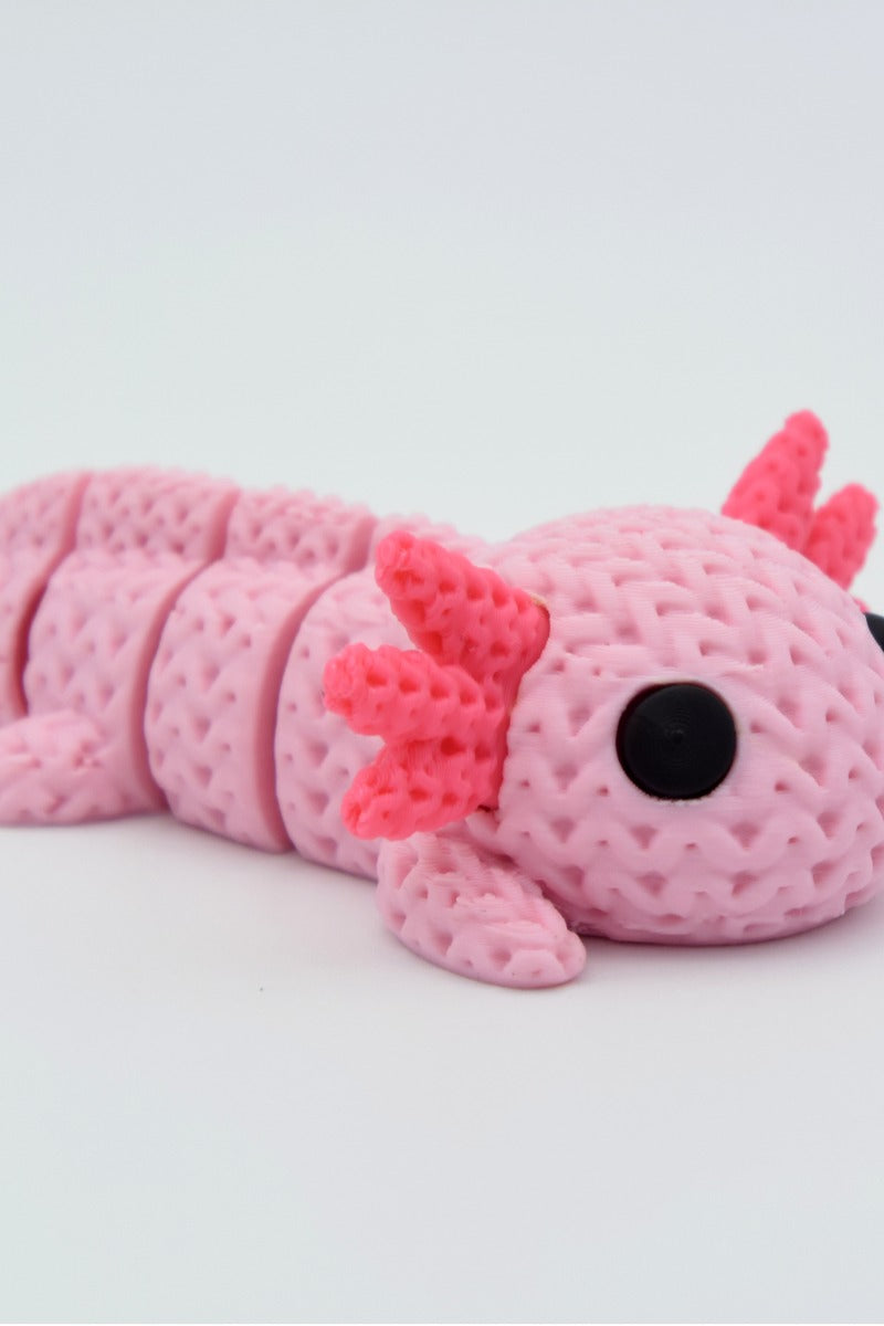 Close-up van een gebreid axolotlfiguurtje in roze met gehaakte textuur