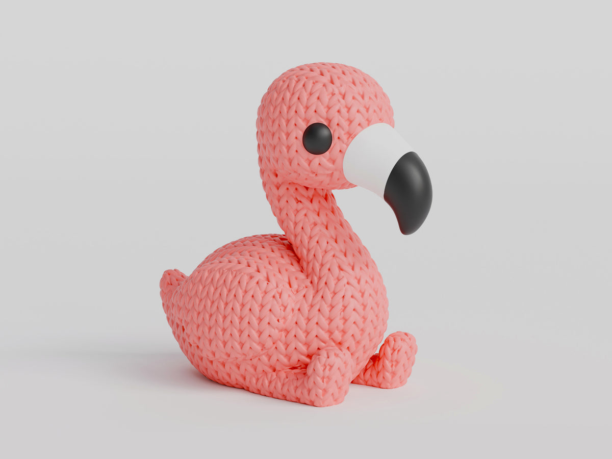 Close-up van een roze gebreid flamingofiguurtje met gehaakte look, rechtop staand