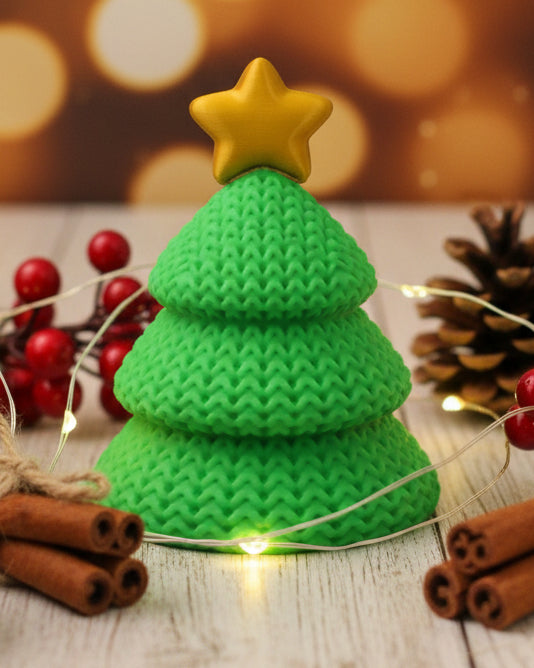 Close-up van een gebreide kerstboomversiering met open gehaakte textuur en een sterretje in de top