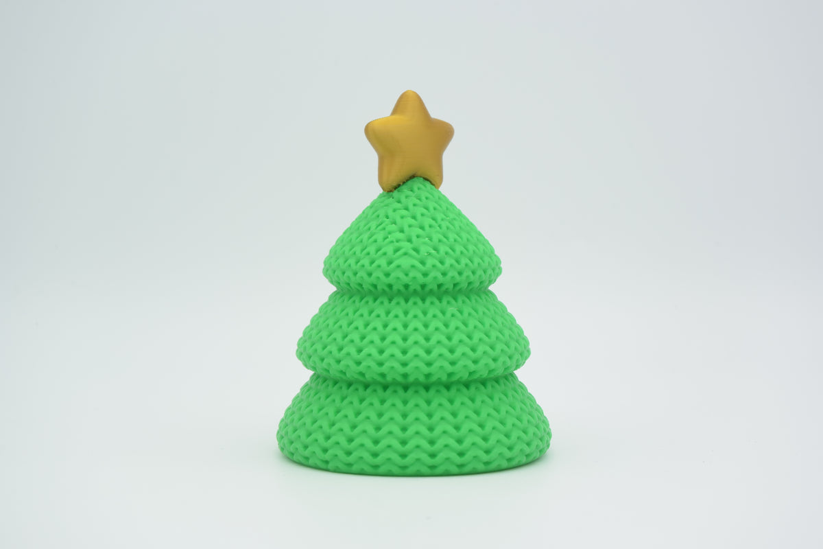Klein gebreid kerstboompje op een houten plank bij kaarsen in Scandinavisch kerstinterieur
