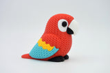 Close-up van een gebreide felgekleurde ara met details in rood, blauw en geel