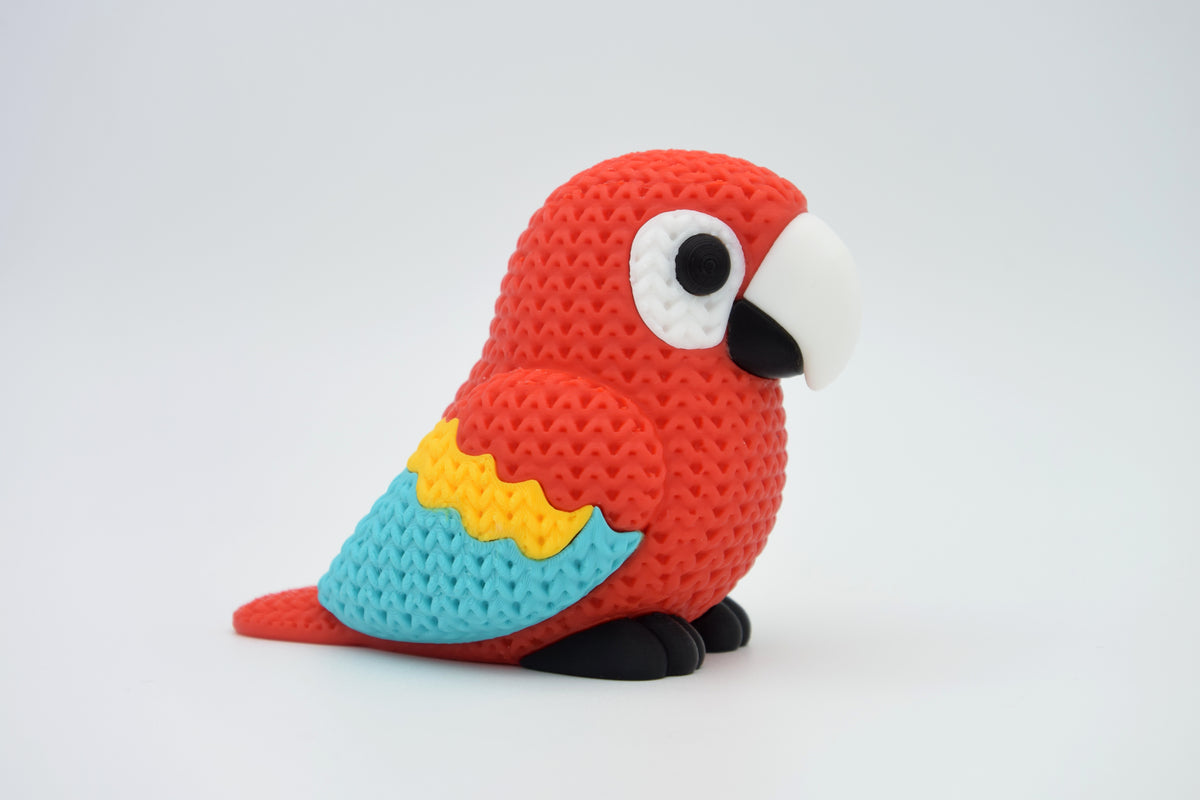 Close-up van een gebreide felgekleurde ara met details in rood, blauw en geel