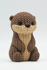 Close-up van een gebreid otterfiguurtje met zachte gehaakte textuur en gedetailleerd gezichtje