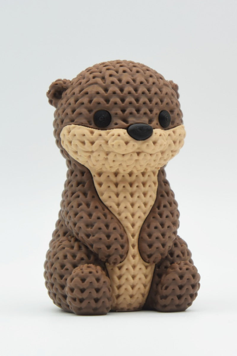 Close-up van een gebreid otterfiguurtje met zachte gehaakte textuur en gedetailleerd gezichtje