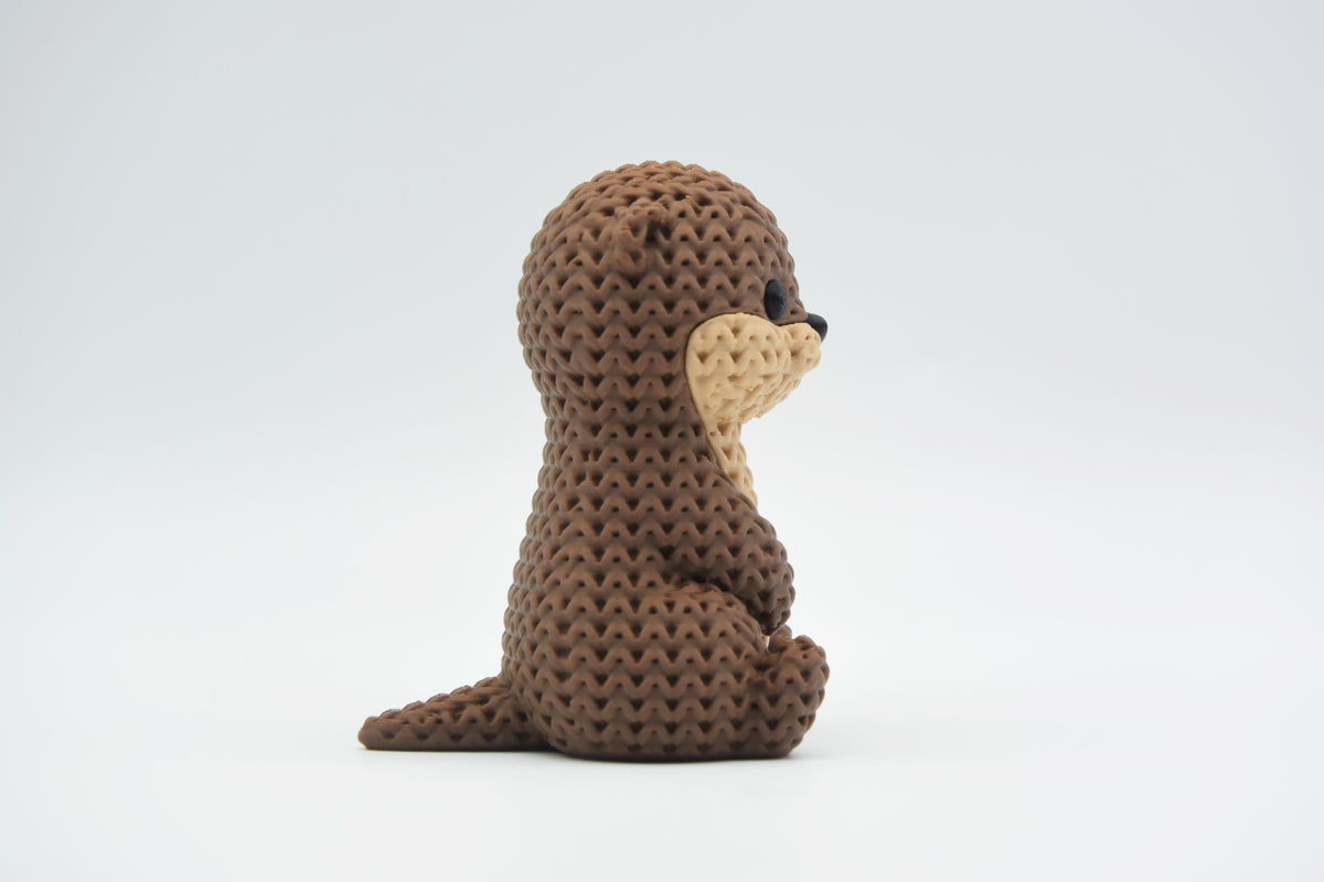 Close-up van een gebreid otterfiguurtje met zachte gehaakte textuur en gedetailleerd gezichtje