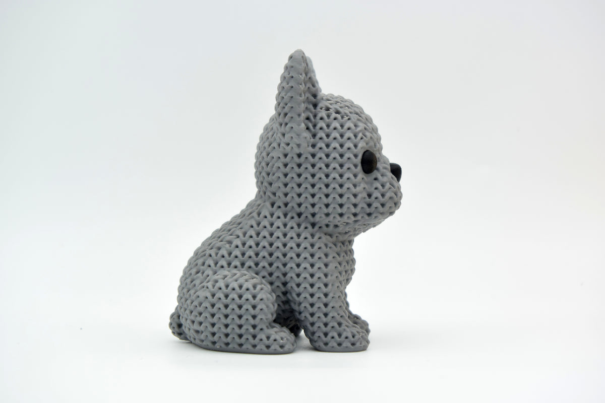 Gebreid Franse bulldog-figuurtje op houten plank naast kleine plant