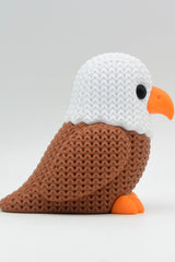 Close-up van een gebreid adelaarsfiguurtje met gehaakte look en gedetailleerde veerribbels